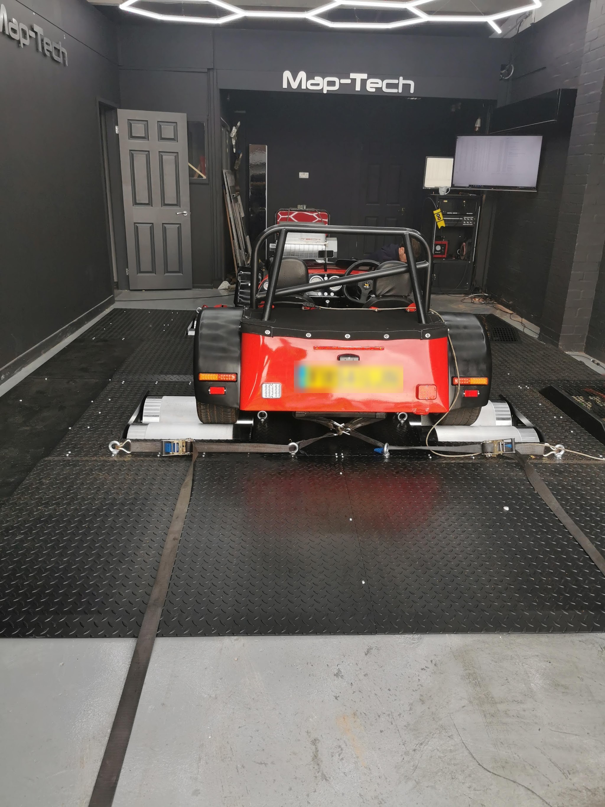 A red open-wheel kit car on the Map-Tech rolling road, with the Map-Tech lettering on the back wall