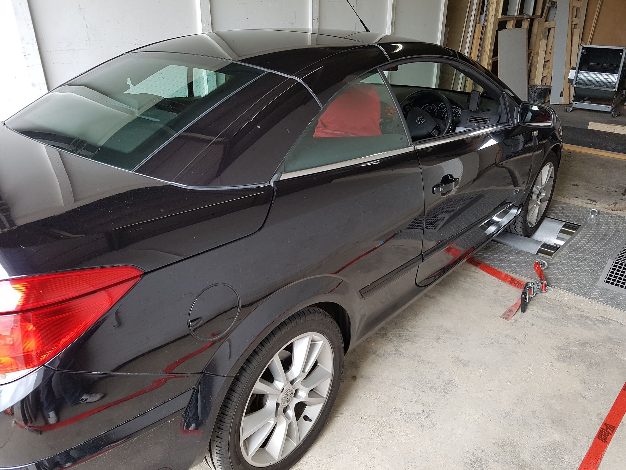A black Vauxhall Astra TwinTop strapped down on the rollers in the Map-Tech bay
