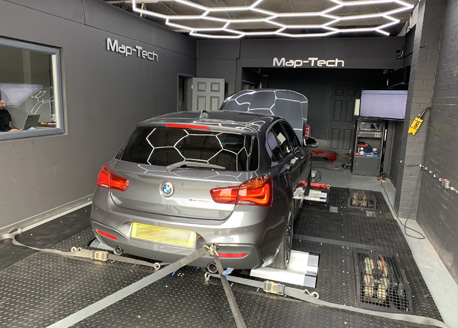 A grey BMW 1 Series on the rolling road under the hexagon LED ceiling
