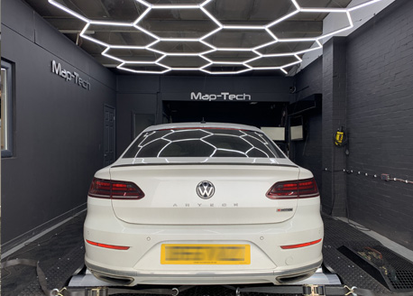 A white Volkswagen Arteon on the rolling road in front of the Map-Tech wall lettering